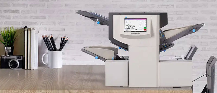 A modern office printer with a touchscreen display on a wooden desk.